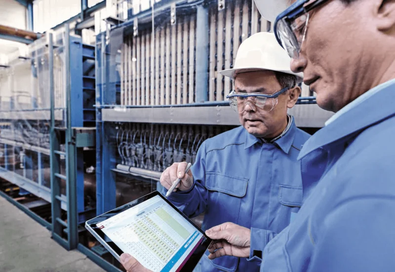 employees talking in front of electrolyzers